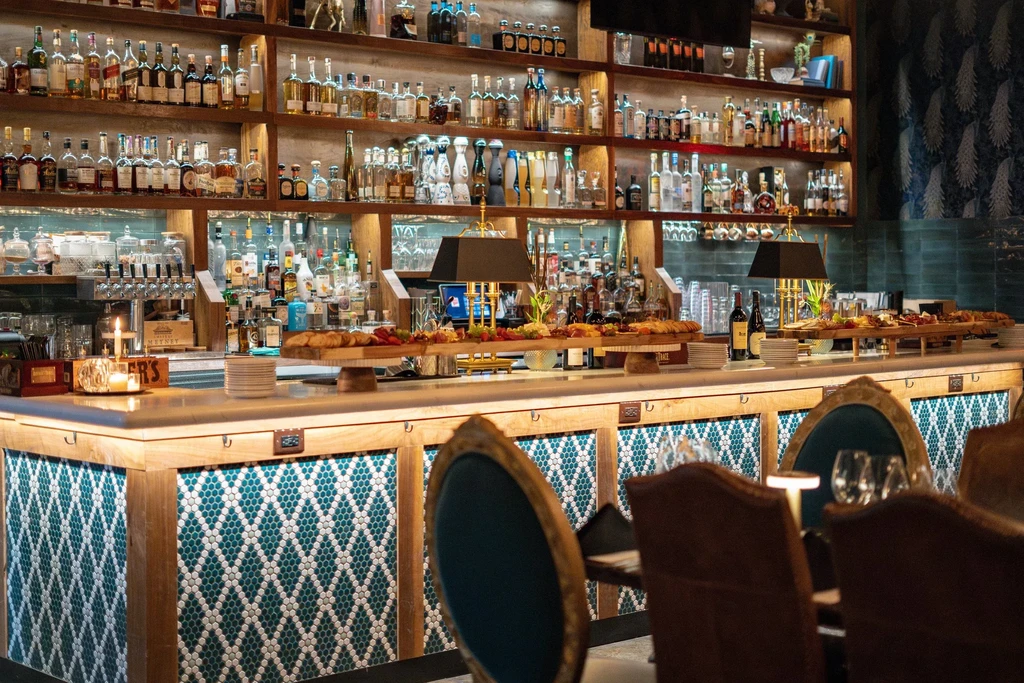 Elegant bar featuring charcuterie, cheeses, fruit, and many liquor bottles.