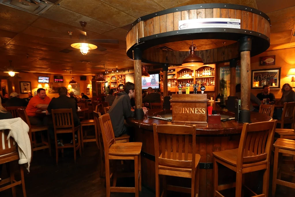 A rustic pub interior with a large circular wooden bar.