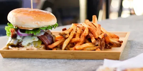 Gourmet bacon cheeseburger with grilled peppers and seasoned golden fries.