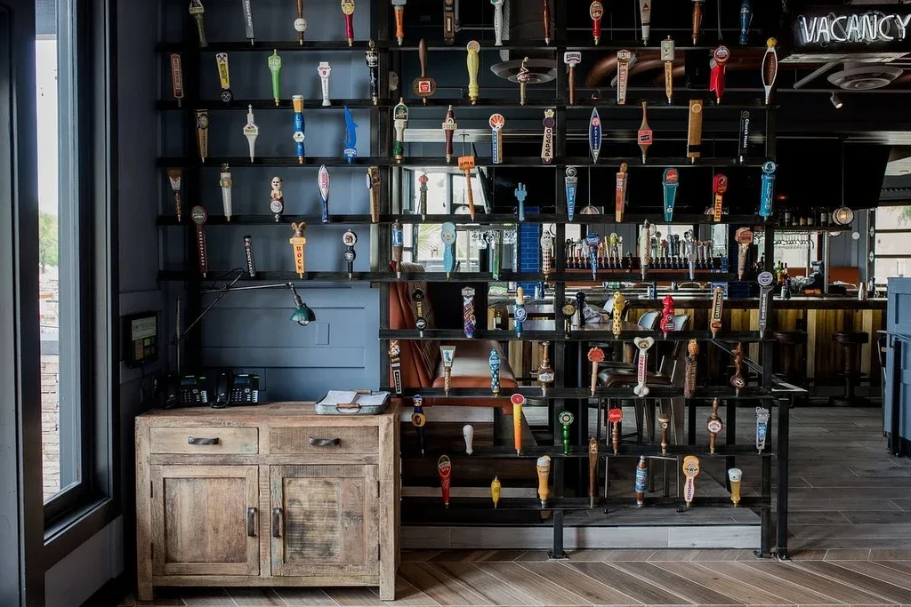 Modern bar interior with a wall of diverse craft beer tap handles.