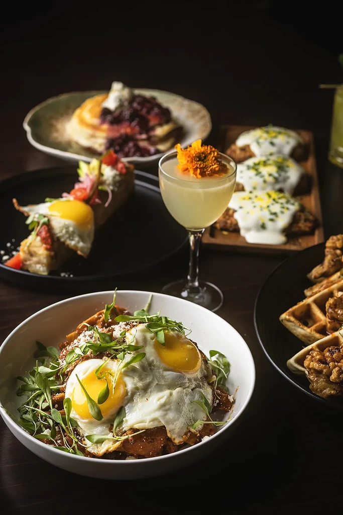 Upscale brunch spread with chilaquiles, chicken & waffles, and pancakes.