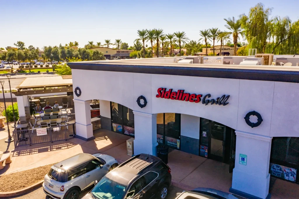 Aerial view of Sidelines Grill restaurant, patio, and strip mall.