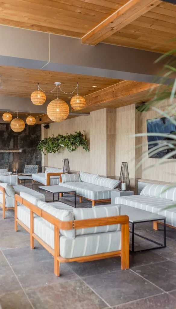 Contemporary lounge with striped benches, wood ceiling, and woven pendant lights.