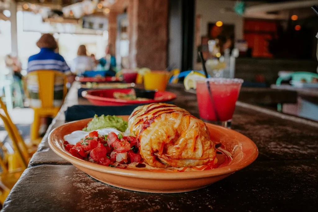 Chimichanga with guacamole, pico de gallo, sour cream, and a red margarita.
