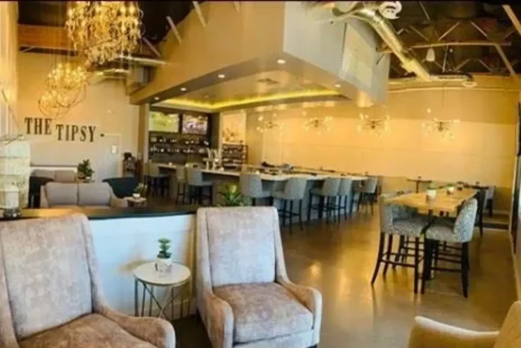 Upscale The Tipsy bar interior with lounge area and long bar.
