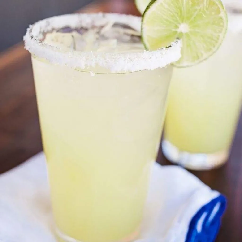 Close-up of two lime cocktails, one with a salt rim.