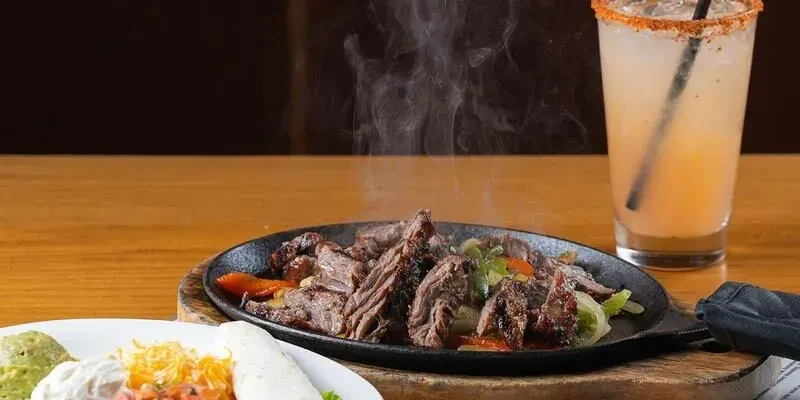 Sizzling beef fajitas, chili-salt rimmed margarita, guacamole, and salsa.