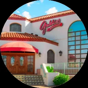 Goldie's Burgers Cafe: White Spanish building with red tile roof and awnings.