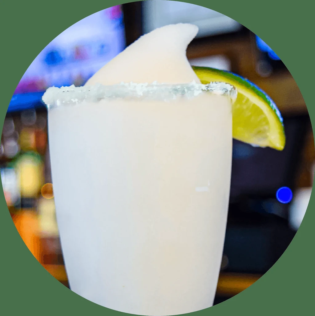 Light frozen drink with ice peak, salted rim, and lime.