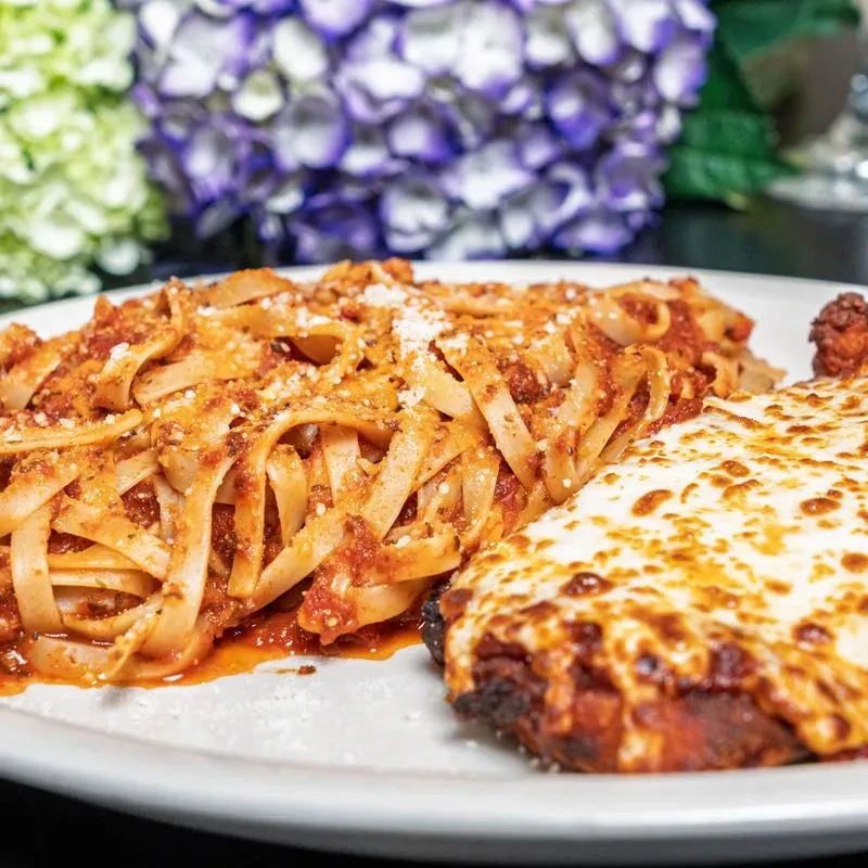 Prepared meal: pasta with red sauce, parmesan, and a cheesy entree.