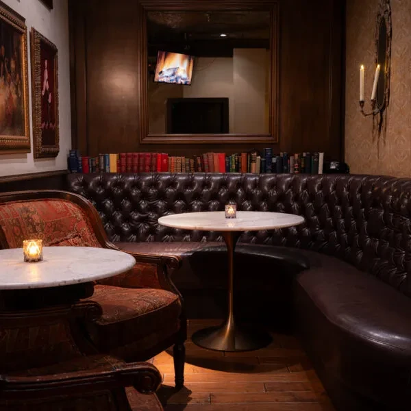 Sophisticated, warm interior with cozy seating, candles, books, and fireplace.