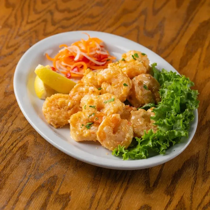 Fried shrimp with creamy sauce, parsley, carrots, onions, and lemon.
