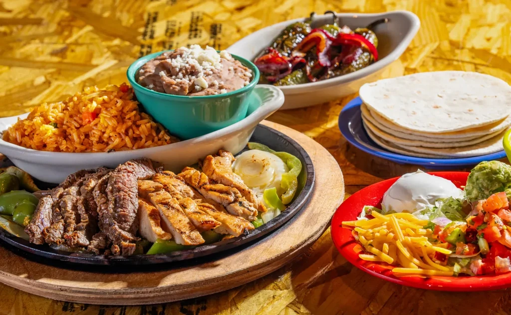 A vibrant spread of Mexican steak and chicken fajitas with sides.