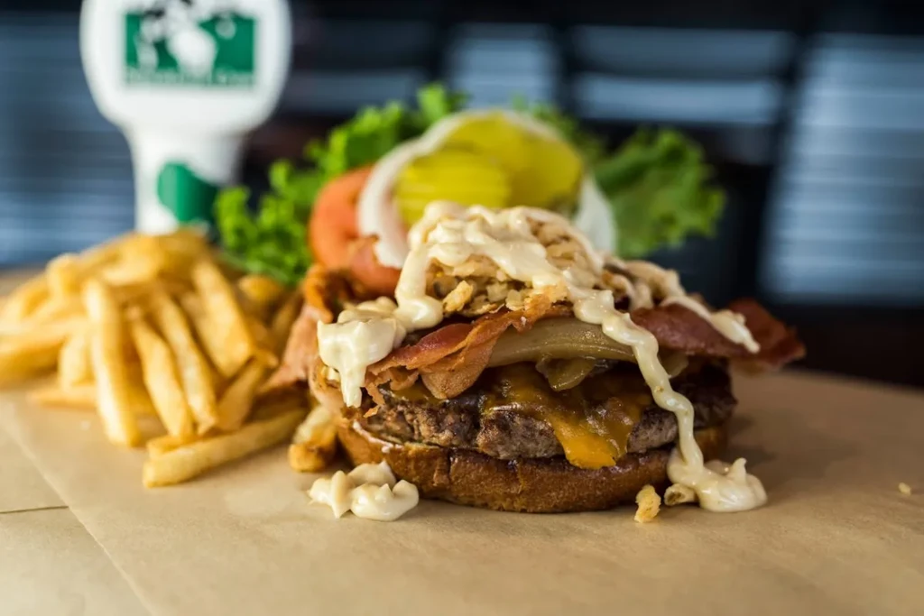 Double cheeseburger with bacon, fried onions, creamy sauce, and golden fries.