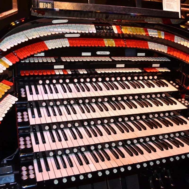 Wurlitzer pipe organ console with multiple manuals and colorful stops.