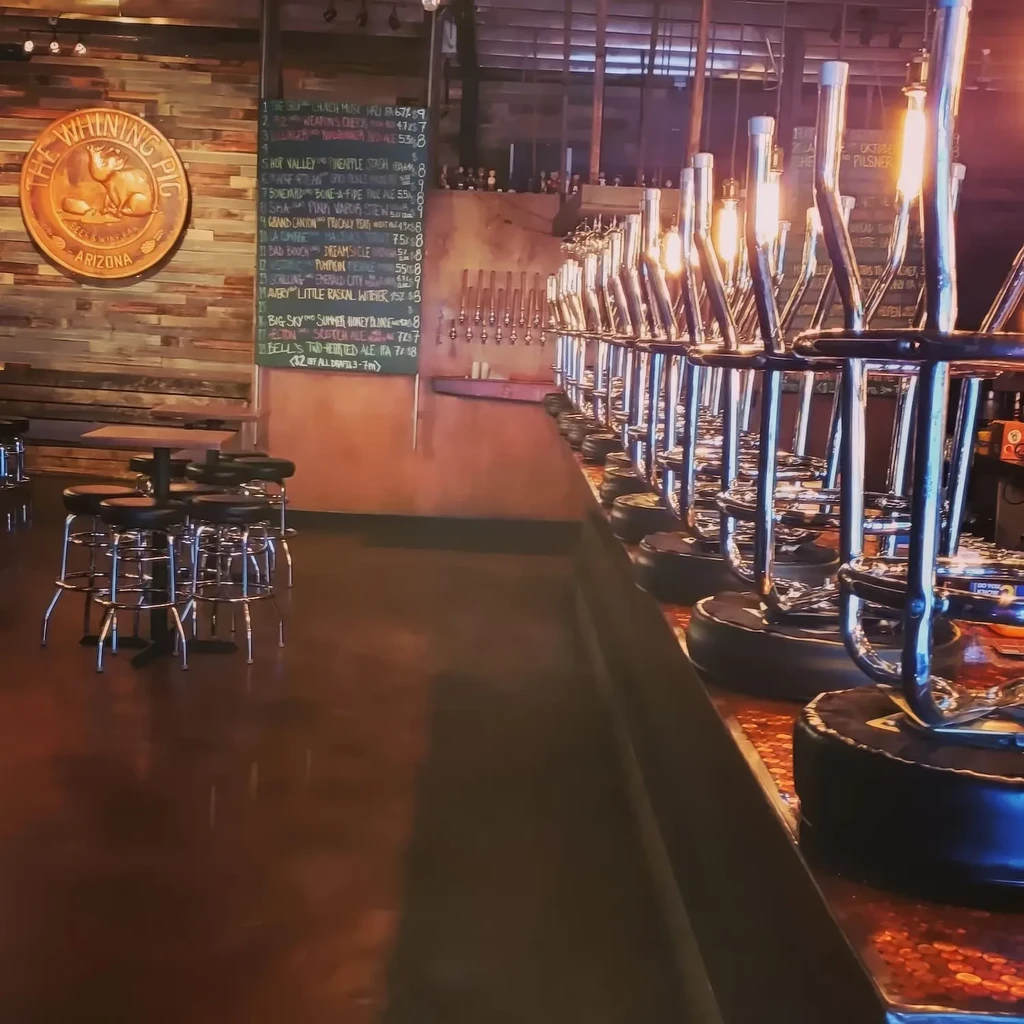 Interior of The Whining Pig Arizona brewpub with bar, taps, and menu.