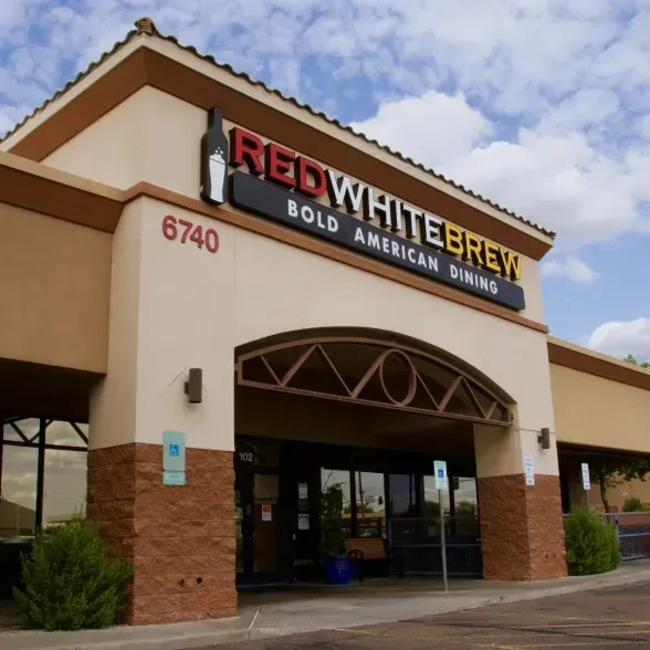Exterior of Red White Brew restaurant with prominent sign and stone columns.