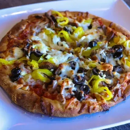 Freshly baked pizza with cheese, black olives, peppers, meat, and onions.