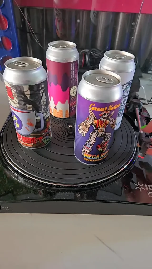 Four distinct, brightly labeled beverage cans on a turntable.