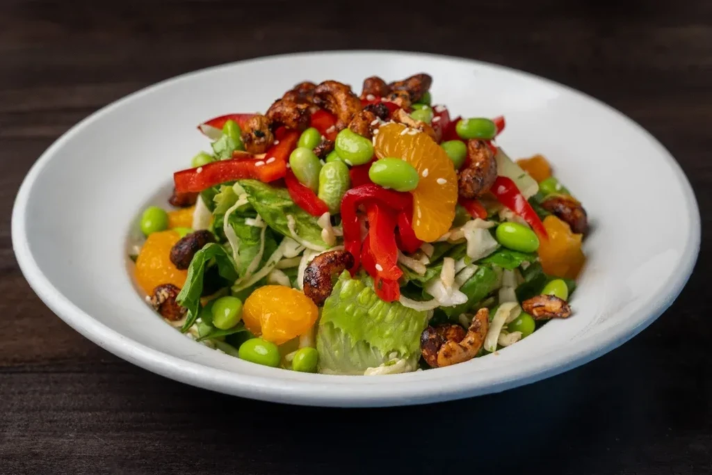 Mixed green salad with edamame, bell pepper, oranges, and candied nuts.