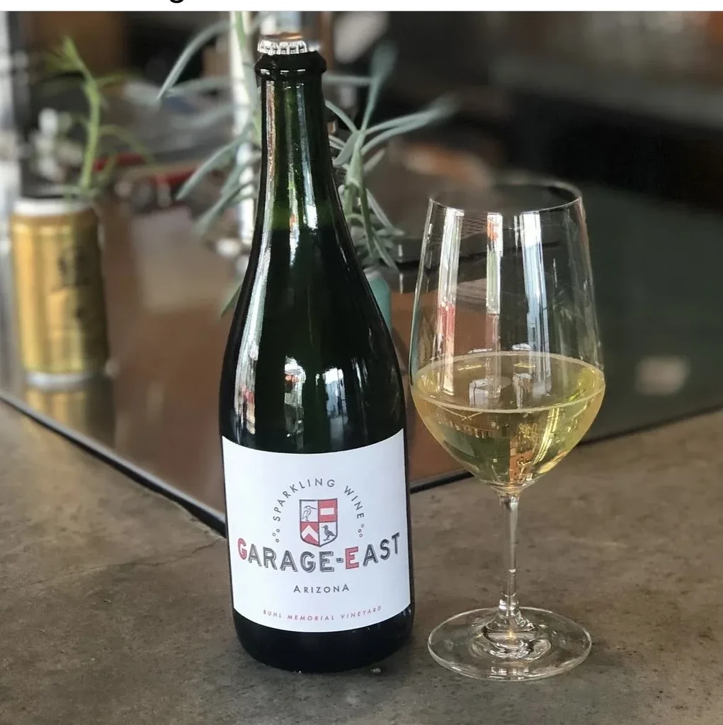 Dark green Arizona sparkling wine bottle and a full glass.