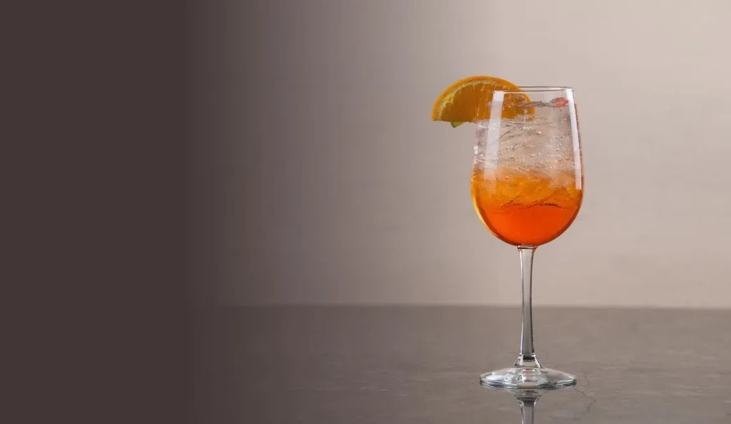 Sparkling orange cocktail in a flute glass with an orange slice garnish.
