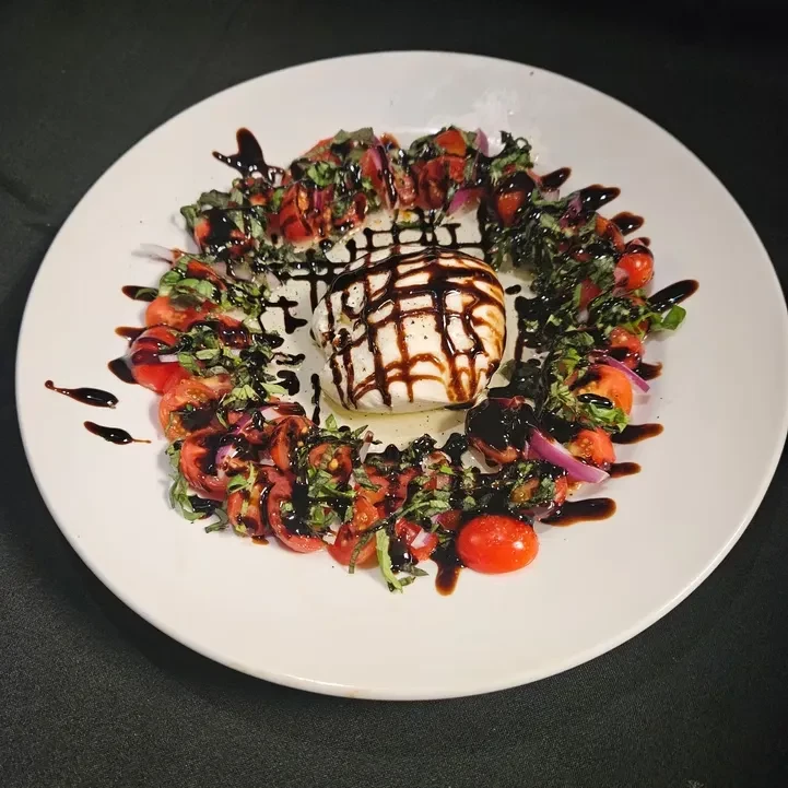 Burrata, tomatoes, basil, red onions drizzled with balsamic glaze.