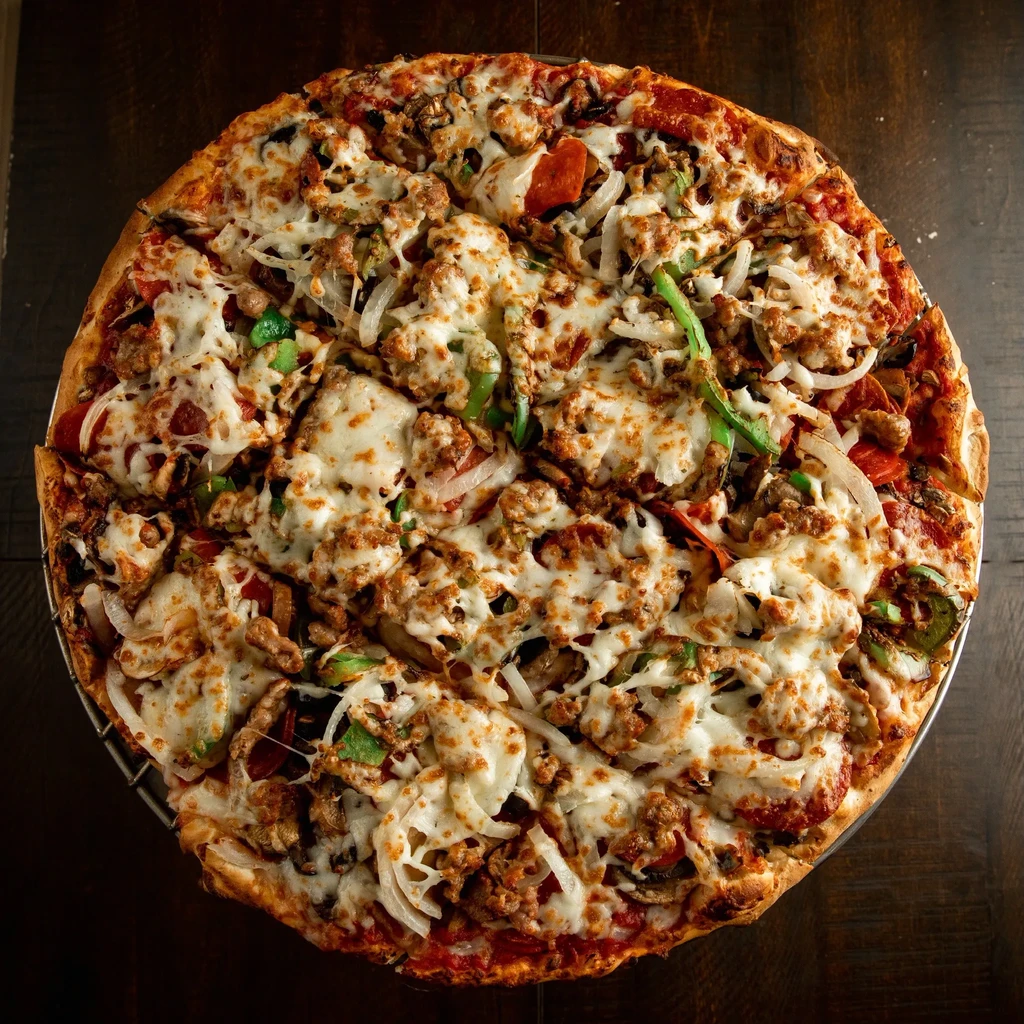 Sliced round pizza with pepperoni, meat, mozzarella, peppers, onions, mushrooms.