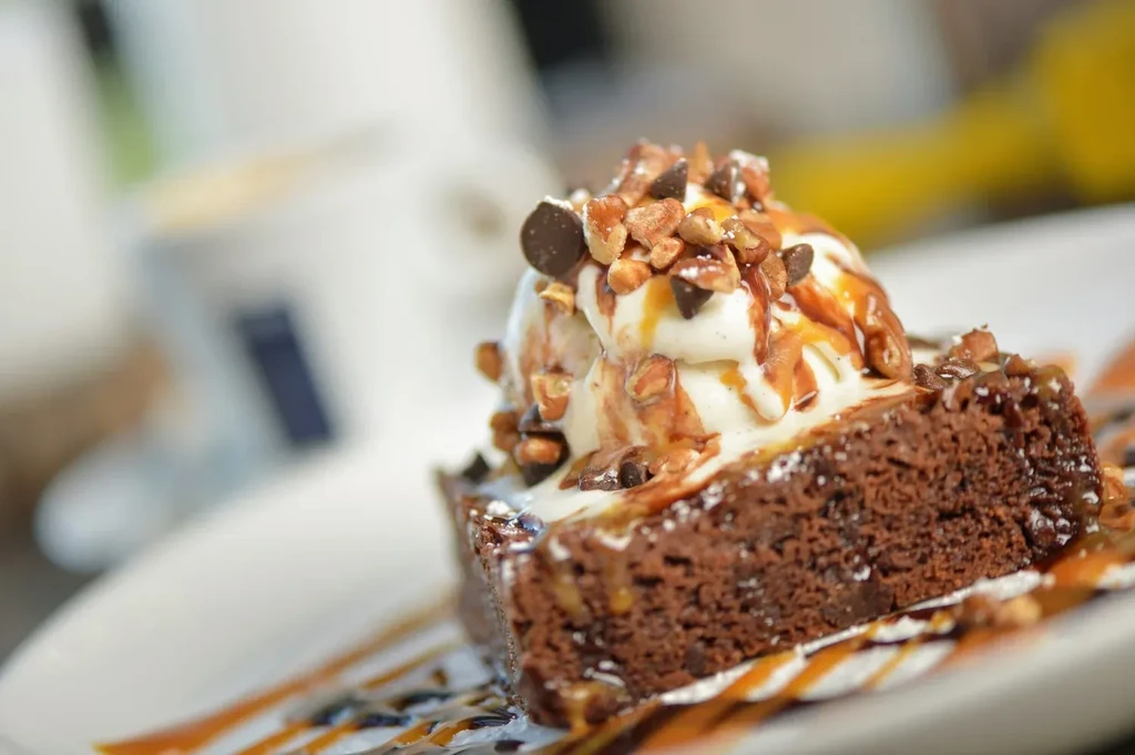 Chocolate brownie topped with vanilla ice cream, sauces, nuts, and chips.