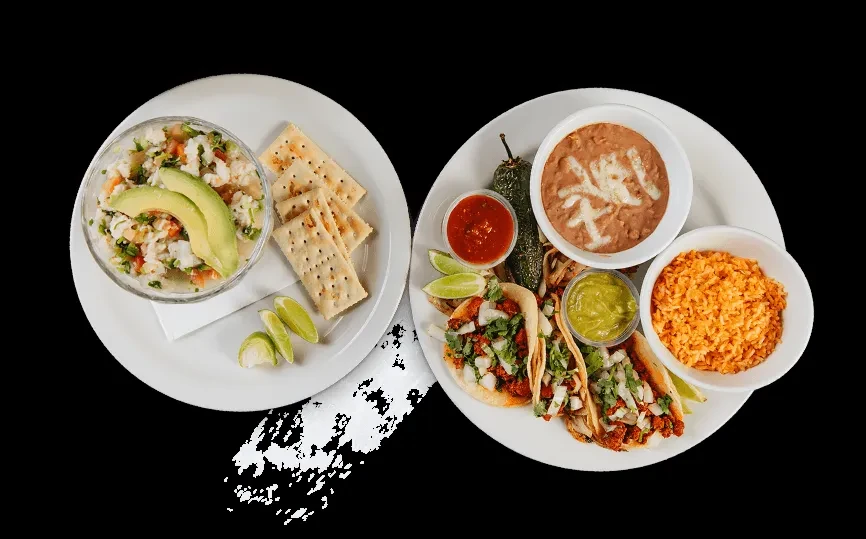 Two plates of Mexican ceviche, tacos, and sides on black.