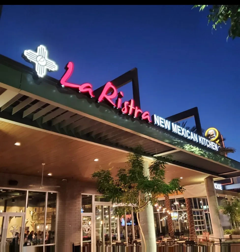 La Ristra New Mexican Kitchen at dusk, glowing pink neon sign and Zia.
