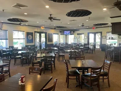 Interior of an empty golf club restaurant with dark wood furnishings.