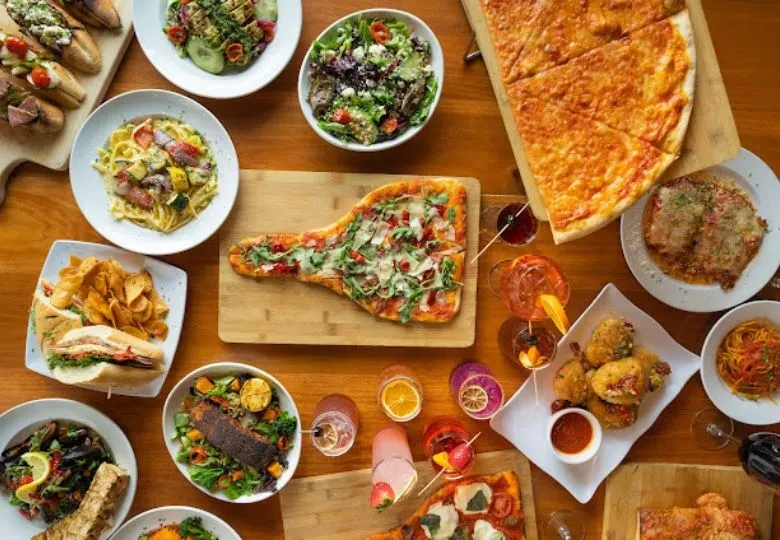 Overhead view of an extensive Italian food and drink spread.