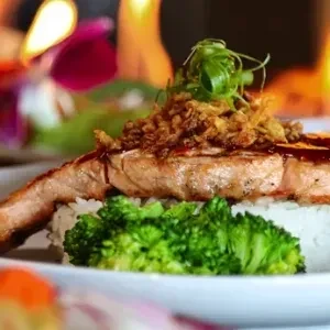Crispy salmon, rice, fried onions, green onions, and steamed broccoli.