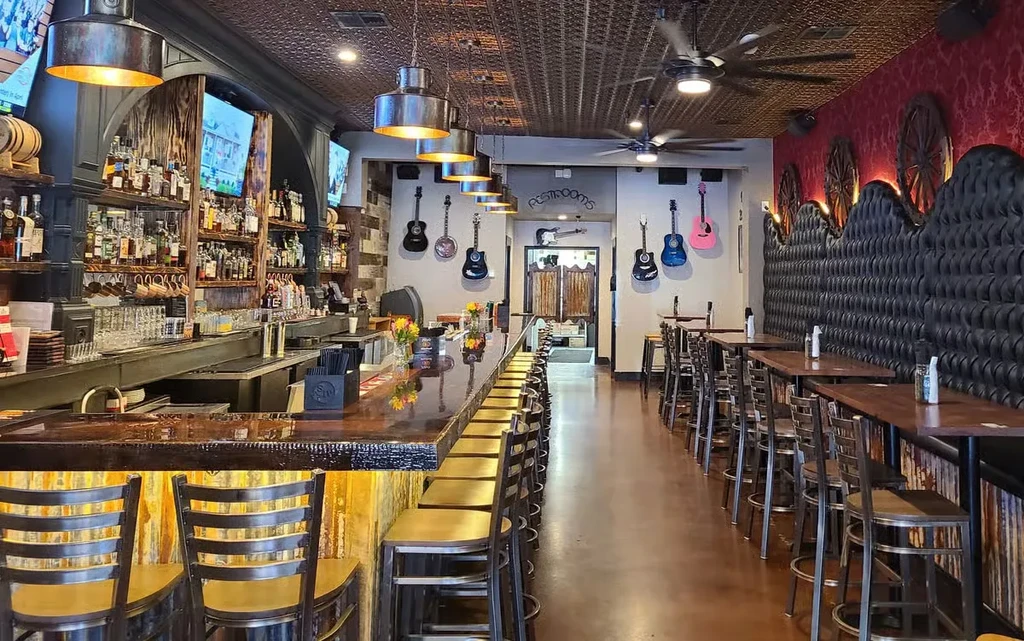 Rustic restaurant interior with a well-stocked bar and western decor.