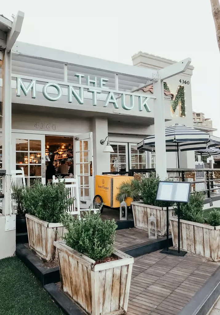 THE MONTAUK restaurant exterior, neon sign, outdoor deck, and champagne cart.