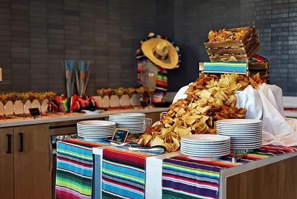 A vibrant Mexican buffet featuring a pile of flour and corn chips.