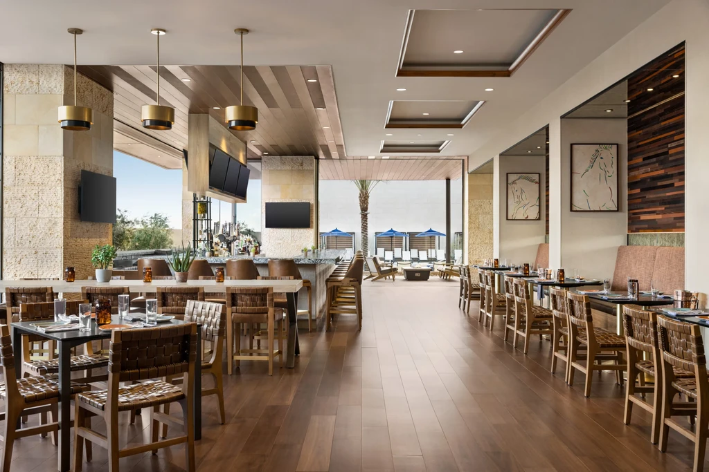 Empty, upscale restaurant interior with bar and outdoor patio.
