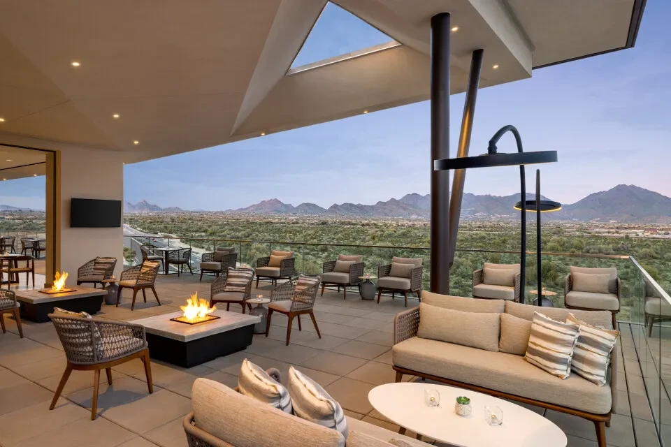 Modern resort patio with fire pits and desert mountain views.