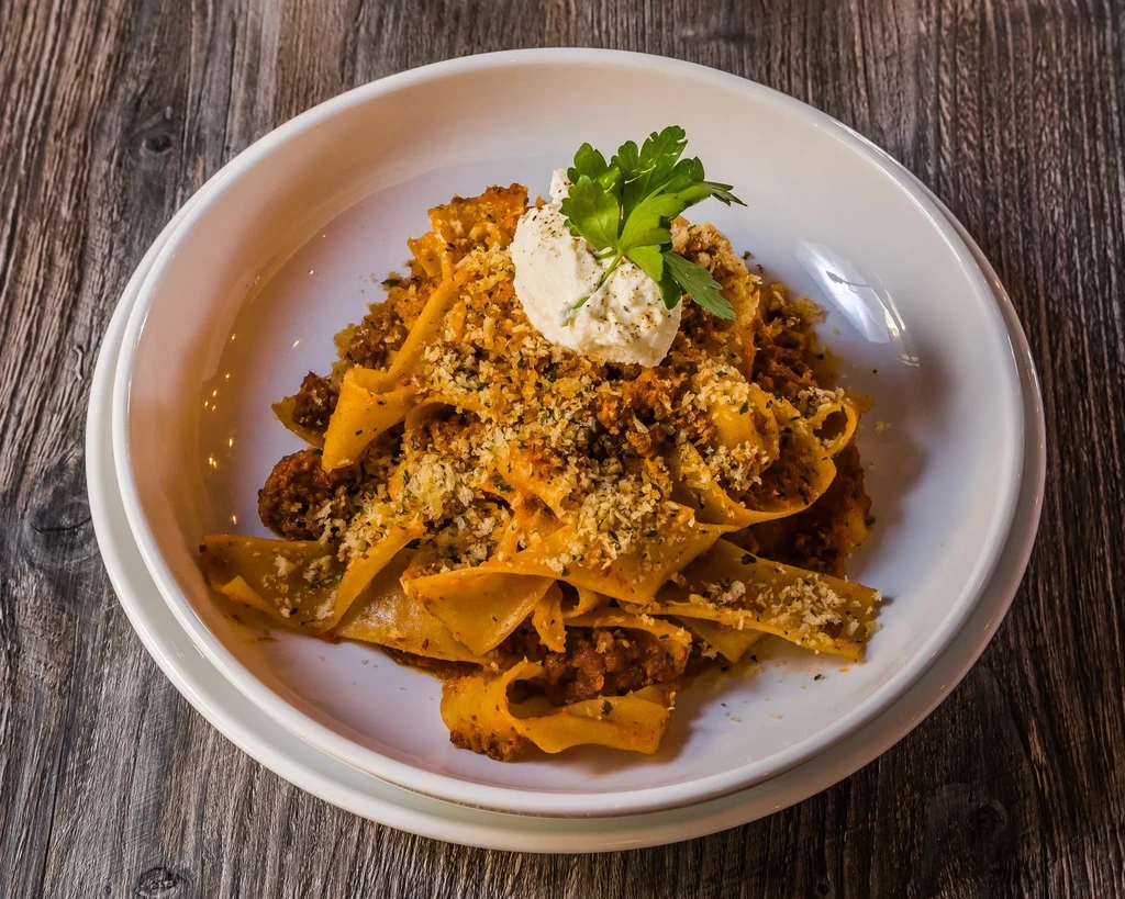 Pappardelle with dark ragu, breadcrumbs, ricotta, and parsley.