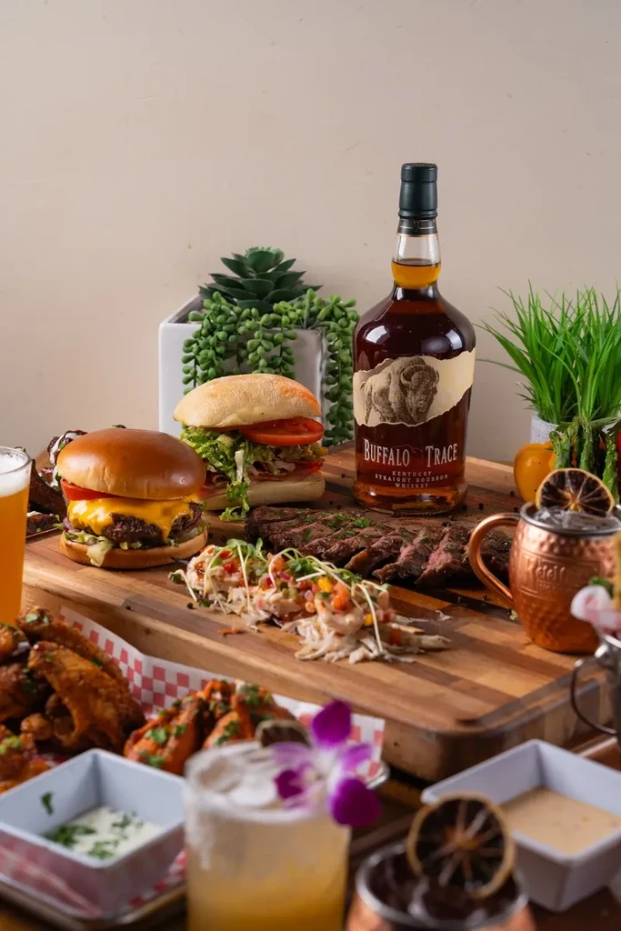 Buffalo Trace bourbon surrounded by burgers, steak, wings, and cocktails.