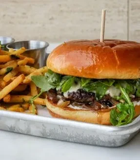 Brioche burger with melted cheese, caramelized onions, seasoned fries.