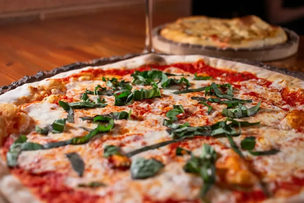 Fresh Margherita pizza with basil, mozzarella, and charred crust.