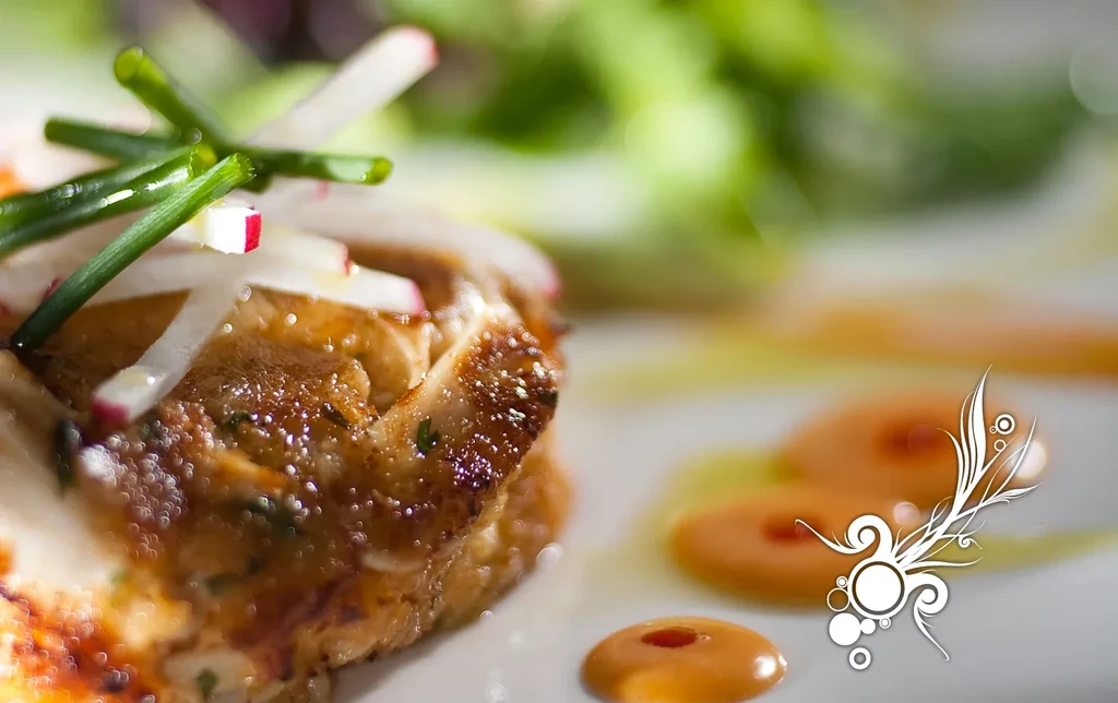 Plated golden meat with chives, radish, orange sauce, and white flourish.