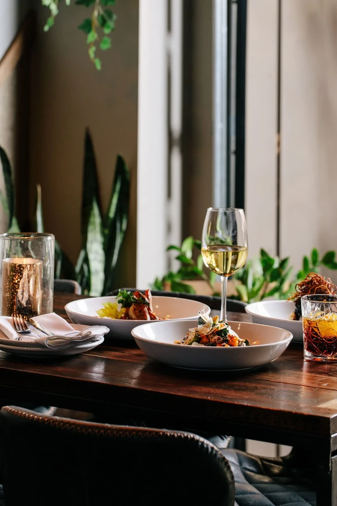 Elegant food, wine, and a cocktail on a modern restaurant table.