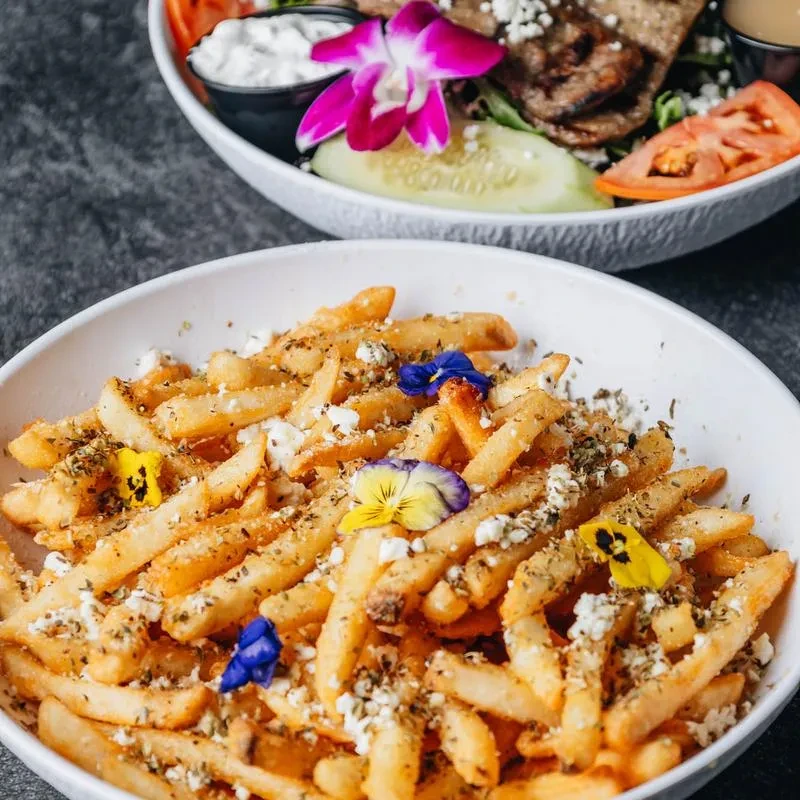 Fries with feta, edible flowers, and a salad with a magenta orchid.