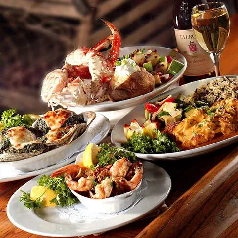 Lavish seafood feast with crab, oysters, shrimp, fish, and white wine.