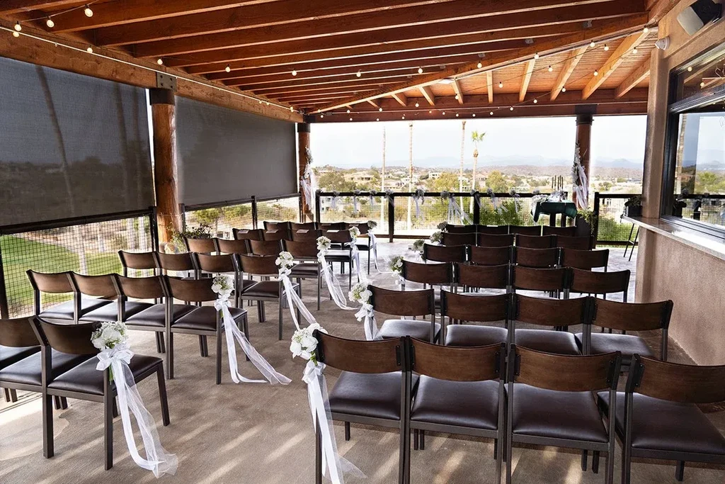 Outdoor patio with floral chairs prepared for a scenic ceremony.