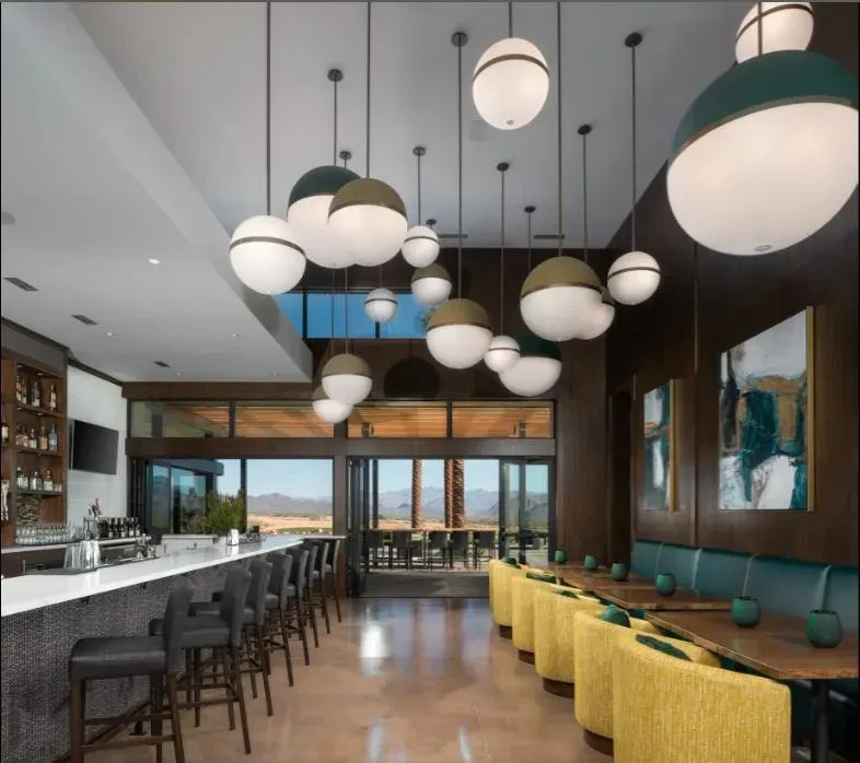 Spacious modern restaurant interior with bar and desert mountain view.