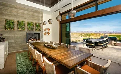 Bright modern dining room opens to desert patio and mountains.